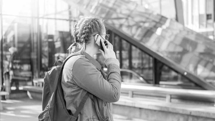 Svartvit bild på en kvinna som talar i telefon. 