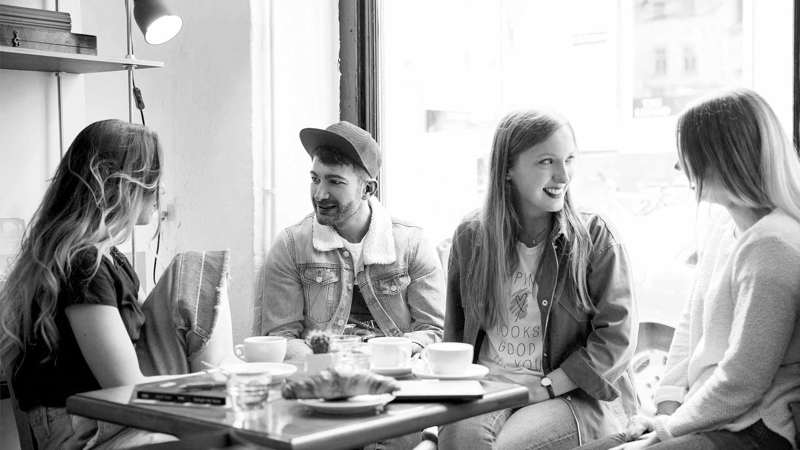 Svartvit bild på fyra personer som samtalar