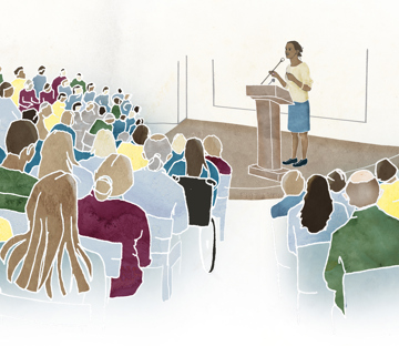 En kvinna föreläser i en aula.