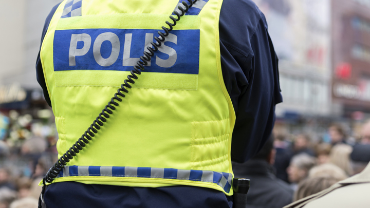 En polis står framför en folksamling.