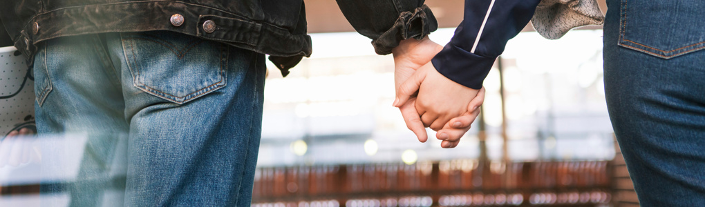 Två personer håller varandra i handen