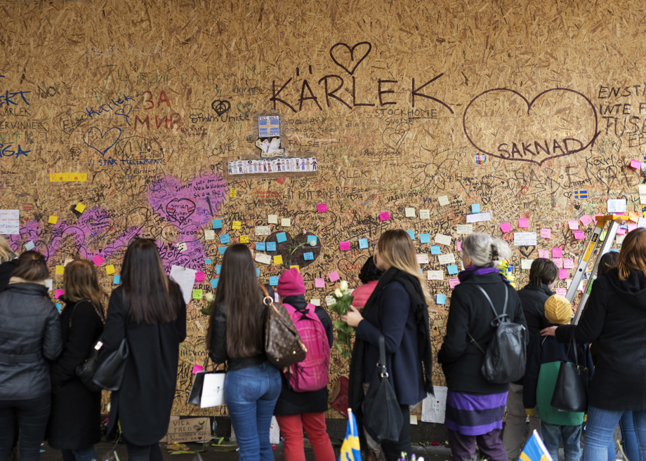 Människor framför en minnesvägg med postit-lappar.