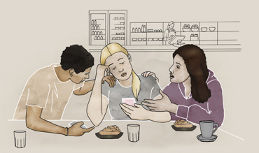 En tjej med mobiltelefon får stöd av två kompisar.