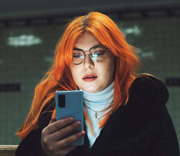Kvinna som tittar på sin mobiltelefon