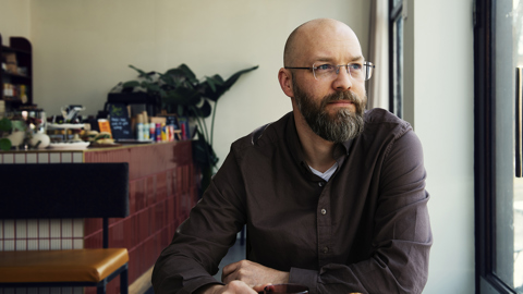 Person som sitter i ett café och tittar ut genom fönstret.