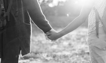 Två unga personer håller varandra i handen.