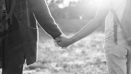 Två unga personer håller varandra i handen.