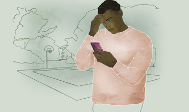 Man som håller en hand mot pannan och tittar i en telefon. 