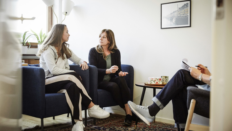 En tjej samtalar med en kvinna och ytterligare en person.